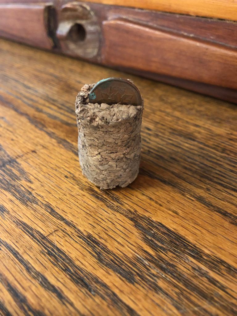 Photo of a cork with a penny in it.