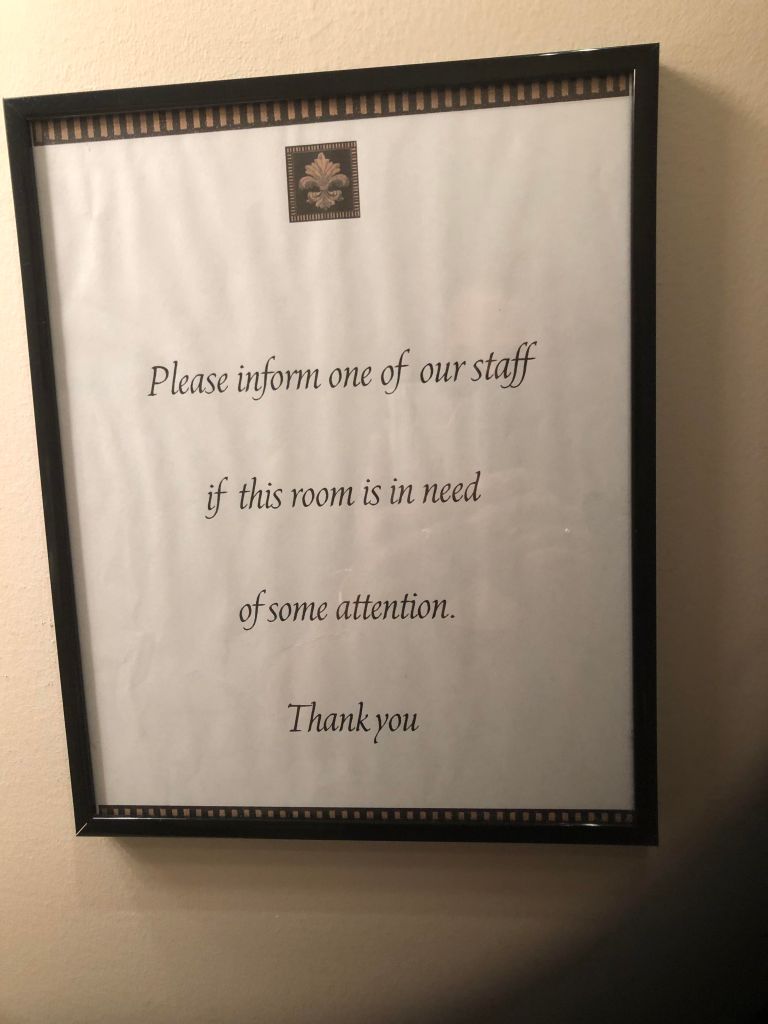 Photo of a sign that says "Please inform one of our staff if this room is in need of some attention."